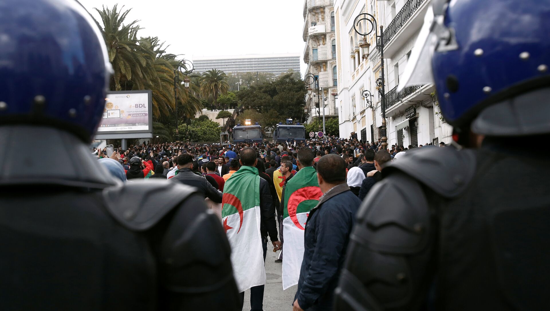 ضباط الشرطة يقفون في أثناء احتجاج على تعيين الرئيس المؤقت عبد القادر بن صالح في الجزائر العاصمة - سبوتنيك عربي, 1920, 18.05.2021