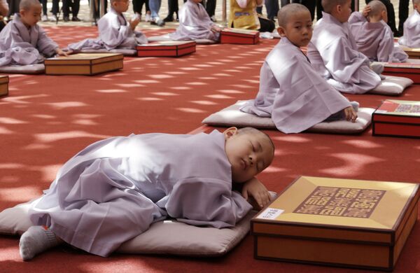 صبي نائم بعد مراسم  التنسيق الرهباني بمناسبة عيد ميلاد بوذا القادم في عام 2563 في معبد جوهي في سيول ، كوريا الجنوبية - سبوتنيك عربي
