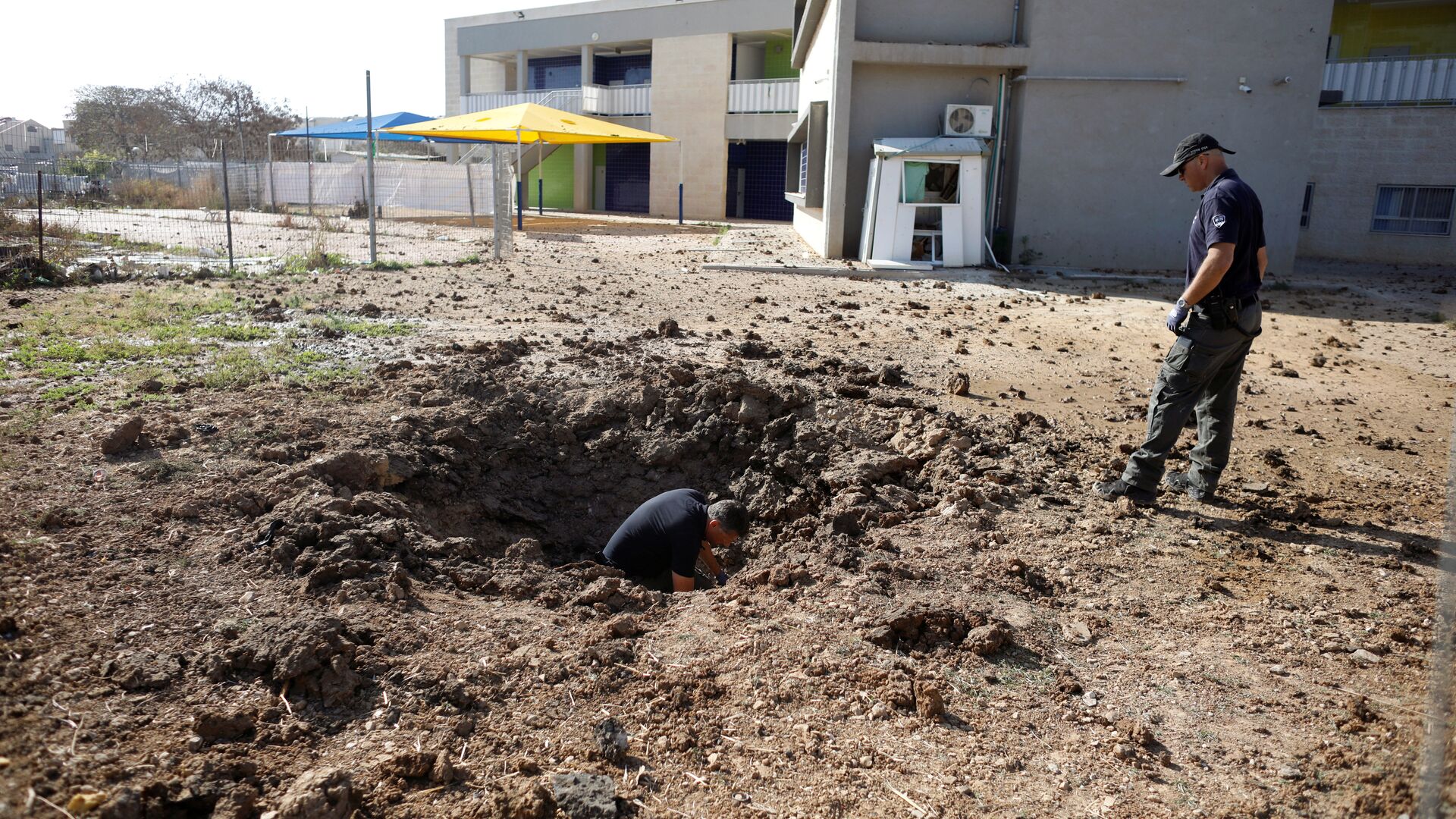 ضباط شرطة إسرائيليين يتفقدون موقع سقط فيه صاروخ أطلق من غزة - سبوتنيك عربي, 1920, 06.08.2022