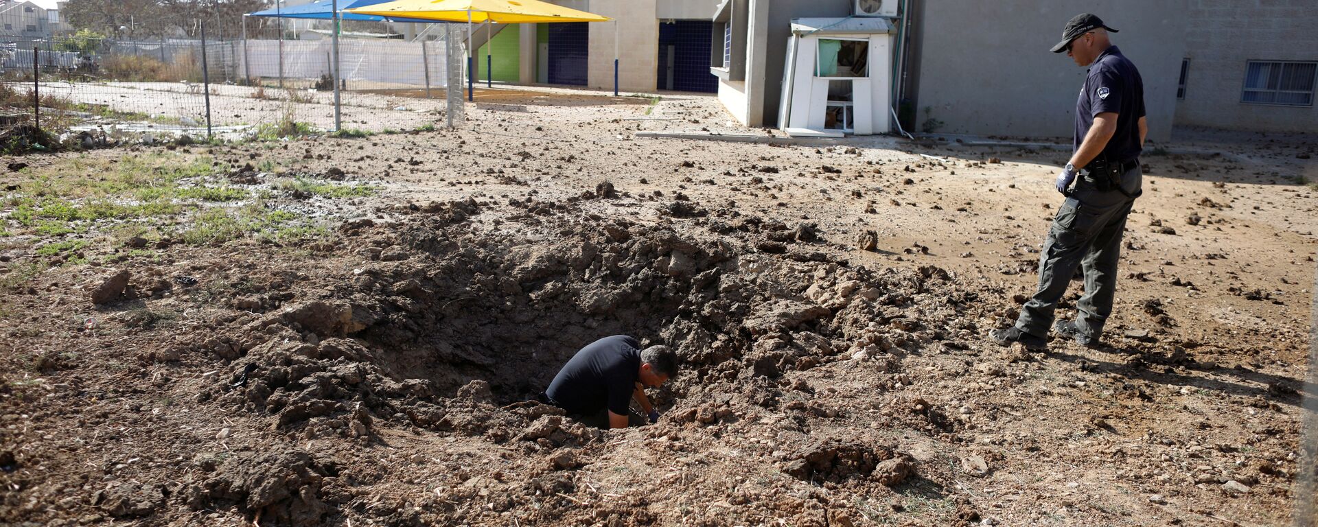 ضباط شرطة إسرائيليين يتفقدون موقع سقط فيه صاروخ أطلق من غزة - سبوتنيك عربي, 1920, 07.05.2022