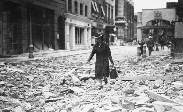 امرأة تحمل حقيبة تمشي على حطام الحرب في لندن عام 1940 - سبوتنيك عربي
