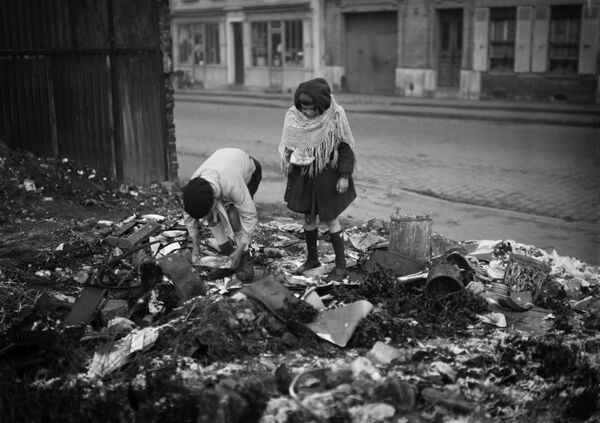 أطفال يفتشون القمامة في أحد شوارع باريس خلال الحرب العالمية الثانية، عام 1945 - سبوتنيك عربي