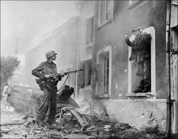 جندي أمريكي يوجه بندقيته نحو جندي ألماني أثناء تحرير فرنسا، عام 1944 - سبوتنيك عربي