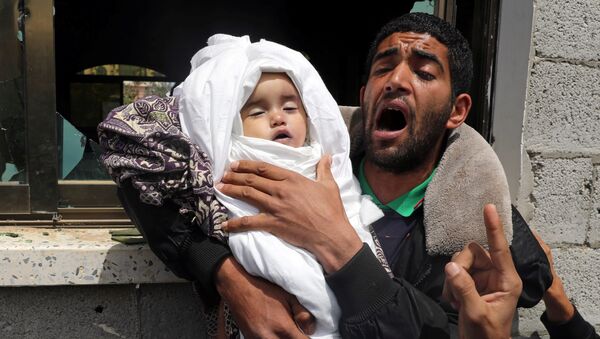 أحد أقارب الطفلة الفلسطينية صبا أبو عرار البالغة من العمر 14 شهرًا يحمل جثمانها خلال جنازتها في مدينة غزة - سبوتنيك عربي