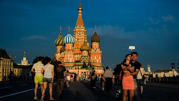 مواطنون وسياح يلتقطون صورة سيلفي على خلفية الساحة الحمراء في موسكو - سبوتنيك عربي