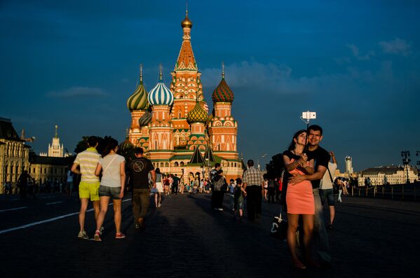 مواطنون وسياح يلتقطون صورة سيلفي على خلفية الساحة الحمراء في موسكو - سبوتنيك عربي