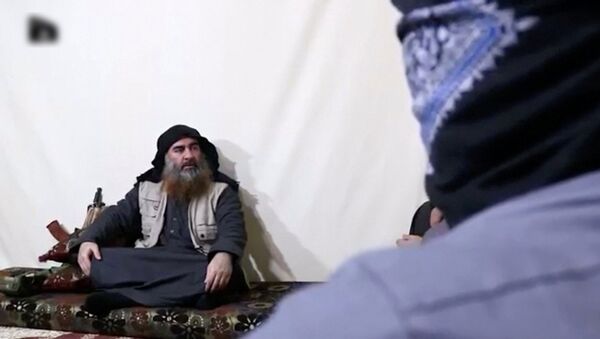 رجل ملتح مع زعيم داعش أبو بكر البغدادي في صورة التي التقطت من شريط فيديو نُشر في 29 أبريل 2019 - سبوتنيك عربي