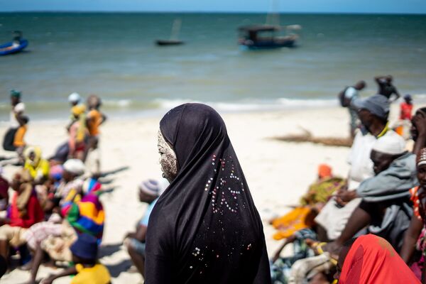 فتاة تقف على الشاطئ في انتظار التوزيع بعد إعصار مدمر في قرية كوموامبا، موزمبيق 13 مايو/ أيار 2019 - سبوتنيك عربي