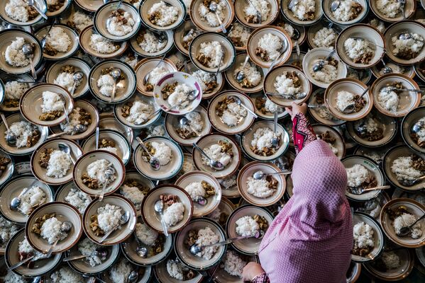 امرأة إندونيسية تعد وجبات للمسلمين في صيام شهر رمضان في مسجد جوكاريان في يوجياكارتا في 11 مايو/ أيار 2019 - سبوتنيك عربي