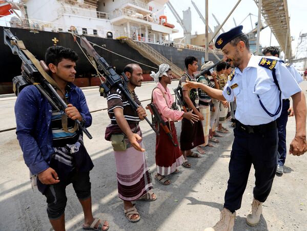 ضابط خفر السواحل اليمني يصافح الحوثيين أثناء مغادرتهم ميناء الصليف في محافظة الحديدة، 11 مايو/ أيار 2019 - سبوتنيك عربي
