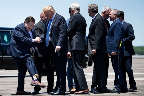 حاكم لويزيانا بيلي نونجيسر يكشف للرئيس الأمريكي دونالد ترامب عن جواربه بعد وصول الرئيس إلى مطار تشينولت الدولي في 14 مايو/ أيار 2019 بولاية لويزيانا - سبوتنيك عربي