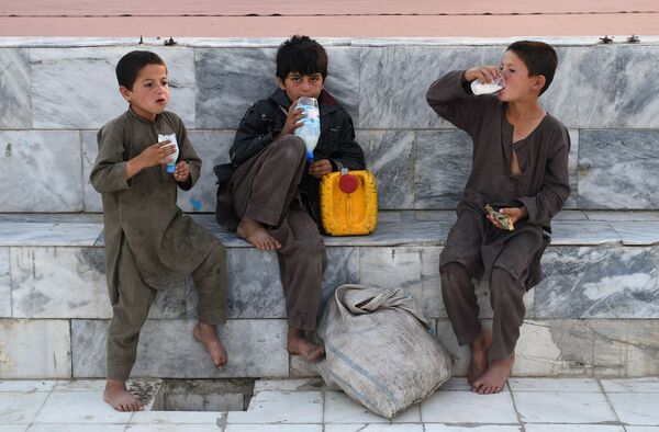 صبيان أفغانيون يشربون مشروبًا يحتوي على اللبن في فناء المسجد الأزرق في مزار الشريف خلال شهر رمضان، مايو/ أيار 2019 - سبوتنيك عربي