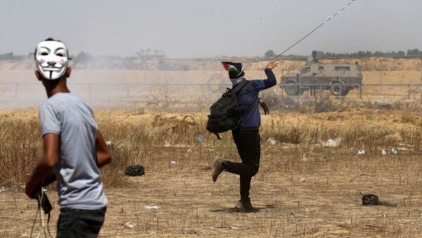 شباب فلسطينيون يقذفون الحجارة في شرق خان يونس، جنوب قطاع غزة، أثناء إحياء الذكرى الـ 71 للنكبة، 15 مايو/ أيار 2019 - سبوتنيك عربي