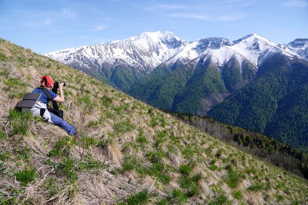 فتاة تلتقط صورا للجبال المغطاة بالثلوج في المحمية الطبيعية القوقازية باسم خ. غ. شابوشنيكوف - سبوتنيك عربي