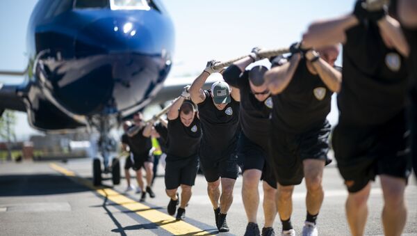 المشاركون في المسابقة السنوية Plane Pull لسحب طائرة من طراز جيت بليو أ320 (JetBlue A320) في مطار جون كينيدي الدولي في نيويورك، 21 مايو/ أيار 2019 - سبوتنيك عربي