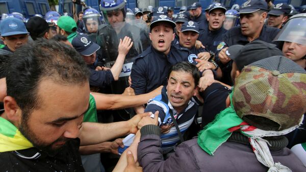 يواجه المتظاهرون وضباط الشرطة بعضهم البعض خلال احتجاج للمطالبة بتأجيل الانتخابات الرئاسية في الجزائر العاصمة - سبوتنيك عربي