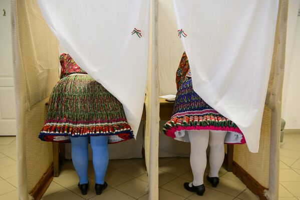 نساء يرتدين الزي الوطني يصوتن في انتخابات البرلمان الأوروبي في مدينة بوياك المجرية، (23-26) مايو/ أيار 2019 - سبوتنيك عربي