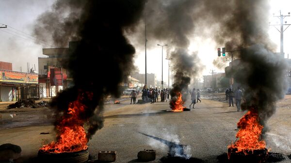 المتظاهرون السودانيون يحرقون إطارات السيارات في الشوارع، مطالبين المجلس العسكري الانتقالي في البلاد بتسليم السلطة للمدنيين في الخرطوم، 3 يونيو/حزيران2019 - سبوتنيك عربي