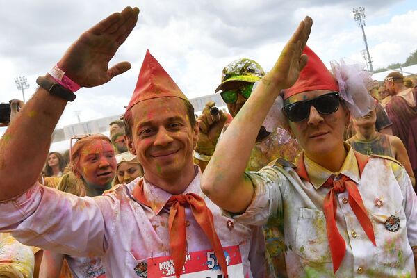 مشاركون يلقون مسحوقًا ملونًا أثناء احتفالهم بعد الانتهاء من سباق الألوان (Colour Run 2019) في ملعب لوجنيكي في موسكو، 2 يونيو/ حزيران 2019 - سبوتنيك عربي