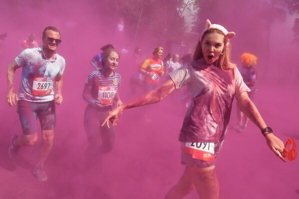 مشاركون يلقون مسحوقًا ملونًا أثناء احتفالهم بعد الانتهاء من سباق الألوان (Colour Run 2019) في ملعب لوجنيكي في موسكو، 2 يونيو/ حزيران 2019 - سبوتنيك عربي