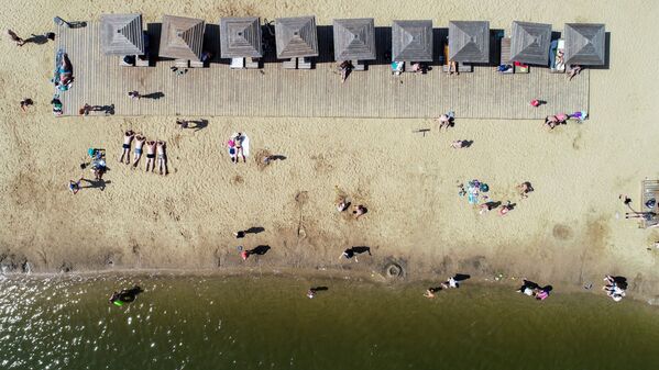 المصطافون على شاطئ منطقة ميشيرسكويه للترفيه والاستجمام في موسكو - سبوتنيك عربي