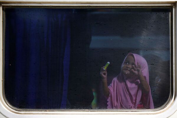 فتاة تُرى داخل قطار سرايو - بوروكيرتو إلى بوروكيرتو بينما يتوجه الناس إلى مسقط رأسهم للاحتفال بعيد الفطر في محطة سينين في جاكرتا، إندونيسيا، 1 يونيو/ حزيران 2019 - سبوتنيك عربي