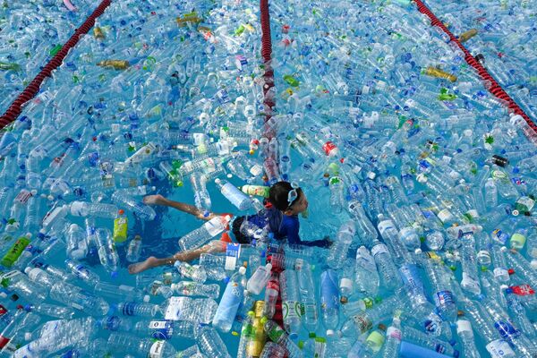 طفل يسبح في بركة مليئة بالزجاجات البلاستيكية في إطار حملة توعية باليوم العالمي للمحيطات في بانكوك، تايلاند 8 يونيو/ حزيران 2019 - سبوتنيك عربي