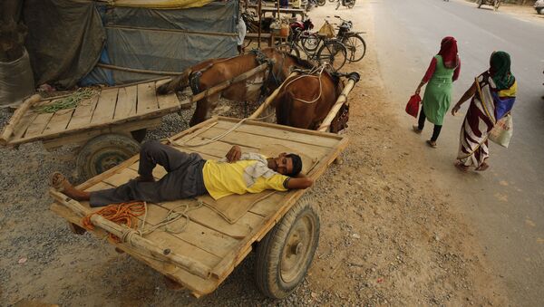 رجل نائم على عربة أثناء موجات الحر في ضواحي براياغراي، الهند، 13 يونيو/ حزيران 2019 - سبوتنيك عربي