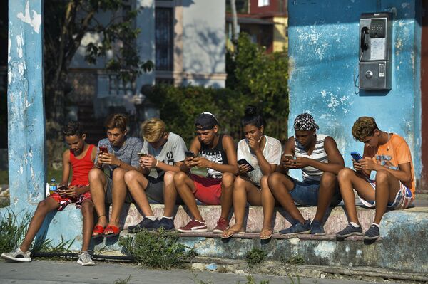 شباب كوبيون مع هواتف محمولة في شارع هافانا، 6 يونيو/ حزيران 2019 - سبوتنيك عربي