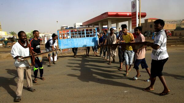 متظاهرون سودانيون يقيمون حاجزًا في أحد الشوارع ويطالبون المجلس العسكري الانتقالي في البلاد بتسليم السلطة إلى المدنيين - سبوتنيك عربي