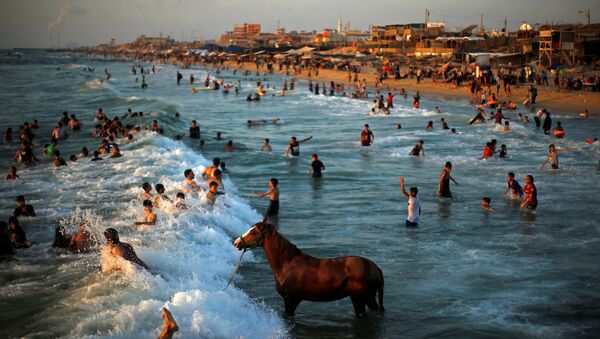 السباحة في البحر الأبيض المتوسط في يوم حار في شمال قطاع غزة في 18 يونيو/ حزيران 2019 - سبوتنيك عربي