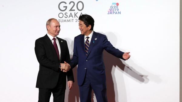 قمة مجموعة العشرين 2019 في مدينة أوساكا، اليابان 28 يونيو/ حزيران 2019 - الرئيس الروسي فلاديمير بوتين مع رئيس الوزراء الياباني شينزو آبي - سبوتنيك عربي