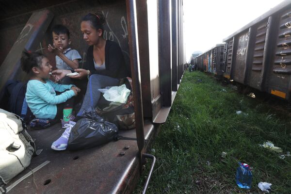 مهاجران: أم وطفل يركبان قطار شحن في طريقهما إلى الشمال، في بالينكو، ولاية تشياباس، المكسيك 24 يونيو/ حزيران 2019 - سبوتنيك عربي