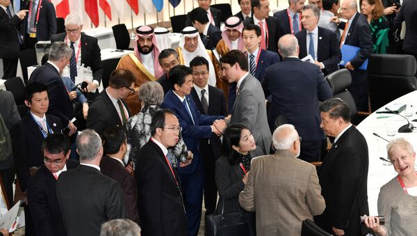 رئيس الوزراء الياباني شينزو آبي يصافح رئيس الوزراء الكندي جاستن ترودو خلال الجلسة الختامية لقمة قادة مجموعة العشرين في أوساكا - سبوتنيك عربي