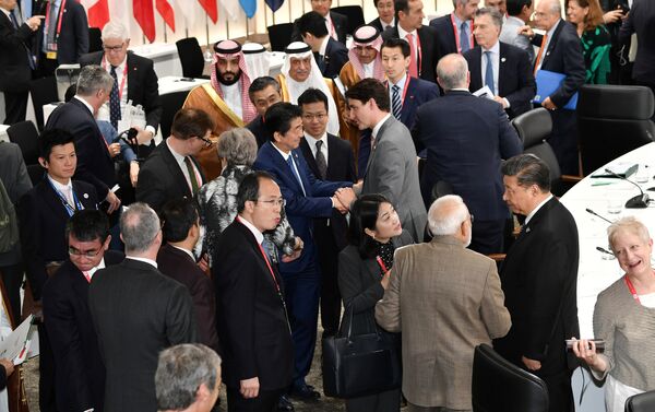 رئيس الوزراء الياباني شينزو آبي يصافح رئيس الوزراء الكندي جاستن ترودو خلال الجلسة الختامية لقمة قادة مجموعة العشرين في أوساكا - سبوتنيك عربي