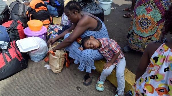 مهاجرون من الكاميرون يستريحون أثناء انتظارهم مع مهاجرين آخرين من أفريقيا وهايتي لدخول مركز احتجاز المهاجرين - سبوتنيك عربي