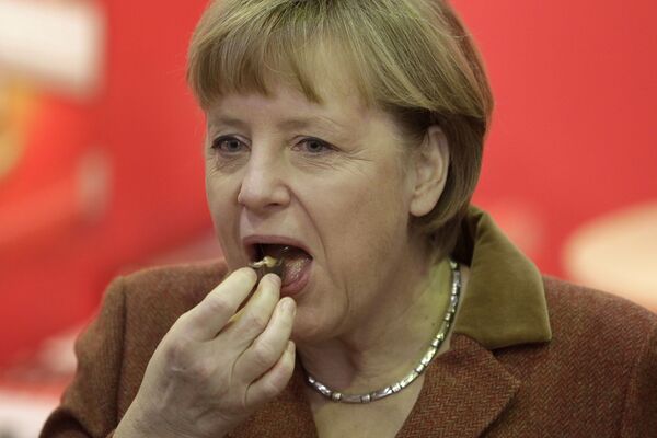 المستشارة الألمانية تأكل قطعة من الشوكولاتة، برلين 18 يناير/ كانون الثاني 2013 - سبوتنيك عربي
