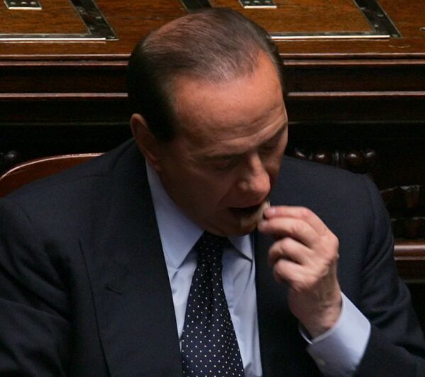 رئيس الوزراء الإيطالي سيلفيو برلسكوني يأكل قطعة من الشوكولاتة في روما، 27 أبريل/ نيسان 2005 - سبوتنيك عربي