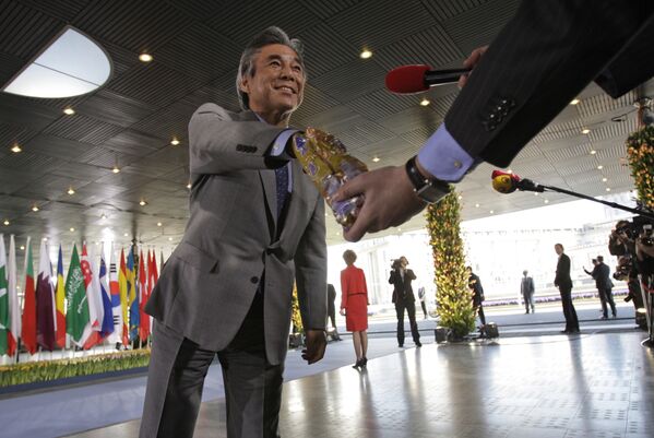 وزير خارجية اليابان هيروفومي ناكاسوني يأخذ بعضا من الشوكولاتة من مراسل قناة تلفزيونية هولندية في مؤتمر في لاهاي بهولندا، 31 مارس/ آذار 2009 - سبوتنيك عربي