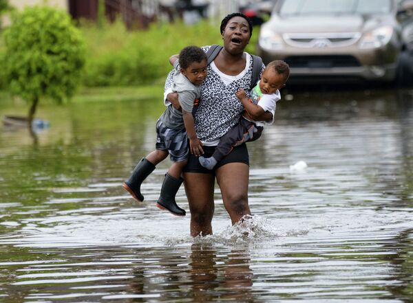 أم تحمل أطفالها بعد طوفان في نيو أورليانز، 10 يوليو/ تموز 2019 - سبوتنيك عربي