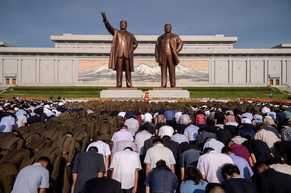 سكان بيونغ يانغ خلال دقيقة صمت أمام النصب التذكاري لكيم إيل سونغ وكيم جونغ إيل في يوم الذكرى الـ 25 لوفاة كيم إم سونغ، بيونغ يانغ، كوريا الشمالية 8 يوليو/ تموز 2019 - سبوتنيك عربي
