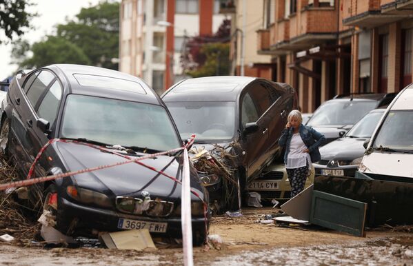 امرأة تتحدث على الهاتف بجوار السيارات المدمرة بعد هطول أمطار غزيرة في تافالا، إسبانيا ، 9 يوليو/ تموز 2019 - سبوتنيك عربي