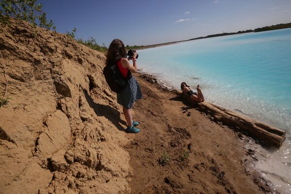 فتيات يلتقطن صورا على خلفية البحيرة القرمزية، التي أطلق عليها أهالي المنطقة المحليون بـ جزر المالديف، 11 يوليو/ تموز 2019 - سبوتنيك عربي