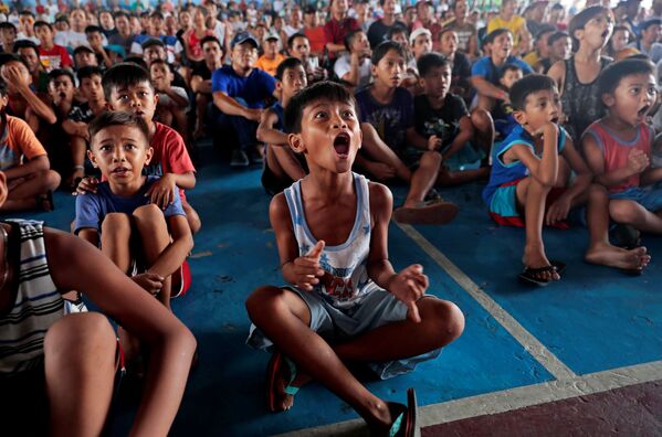 عشاق الملاكمة الفلبينيين يفرحون بعد فوز ماني باكوياو بمباراة ضد نظيره الأمريكي  كيث ثورمان خلال البث المباشر للمباراة المكلامة للوزن الوسط التابعة لرابطة الملاكمة العالمية في ماريكينا، الفلبين، 21 يوليو/ تموز 2019 - سبوتنيك عربي