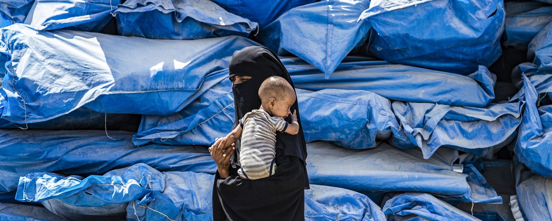 امرأة تحمل طفلاً في مخيم الهول للنازحين في الحسكة، شمال شرق سوريا 22 يوليو/ تموز 2019 - سبوتنيك عربي, 1920, 13.04.2023