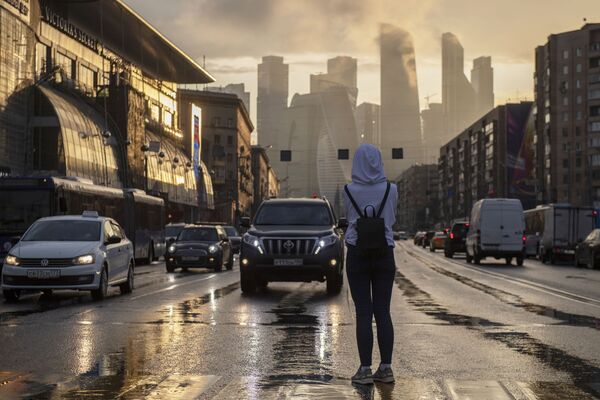 فتاة تتوقف على ممر للمشاة في حي كوتوزوفسكي بروسبيكت لتلتقط صورة لمجمع موسكو سيتي وسط موسكو. - سبوتنيك عربي