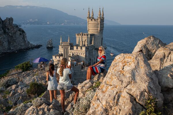 سياح يلتقطون صورا على خلفية قلعة السنونو خارج يالطا، القرم، روسيا - سبوتنيك عربي