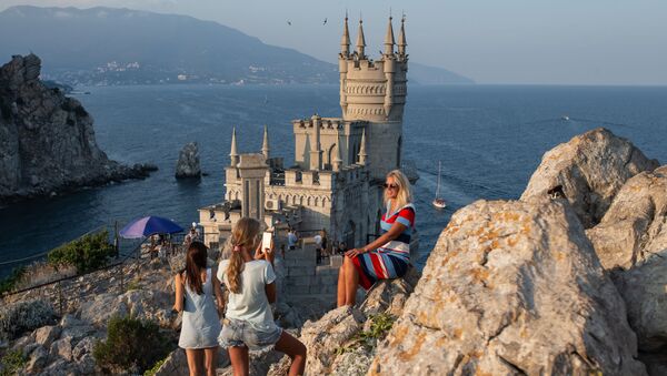سياح يلتقطون صورا على خلفية قلعة السنونو خارج يالطا، القرم، روسيا - سبوتنيك عربي