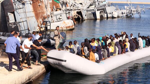  خفر السواحل الليبي يقوم بسحب قارب يحمل مهاجرين أفارقة، تم إنقاذهم أثناء محاولتهم الوصول إلى أوروبا بطريقة غير شرعية، في قاعدة بحرية بالقرب من العاصمة طرابلس في 29 سبتمبر/ أيلول 2015. - سبوتنيك عربي