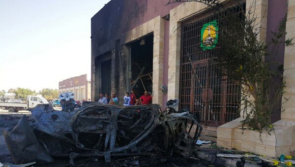 أشخاص يتجمعون في الموقع الذي انفجرت فيه سيارة مفخخة في بنغازي - سبوتنيك عربي